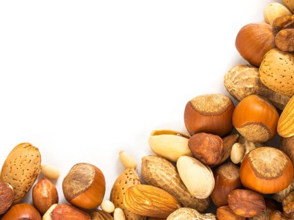 Background of closeup mixed nuts - hazelnuts, almonds, walnuts, pistachios, peanuts, pine nuts