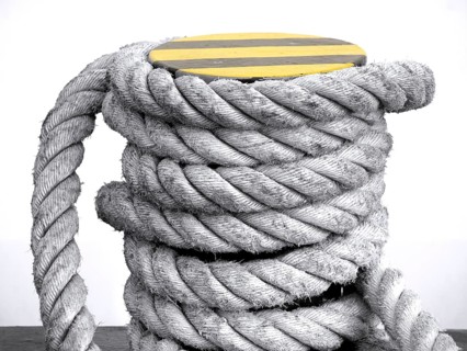 Iron mooring post with a thick rope wrapped around it