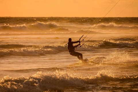 Single surfer at sunset on a calm ocean