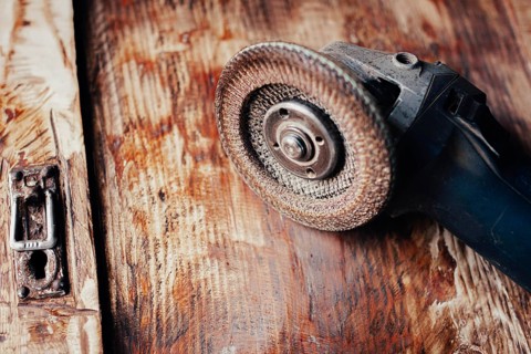 Close-up of an angle grinder on a textured wooden surface