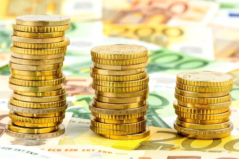 Stack of coins, falling curve, symbolic photo for falling interest rates and falling costs Austria
