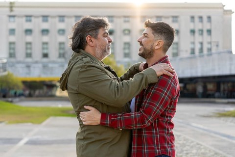 Two married men who are in love are embracing each other