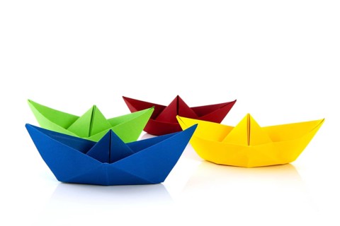 Colorful folded paper boats isolated over white background
