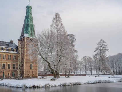 Snow-covered castle and lake in winter with trees and historic architecture, Raesfeld, münsterland,