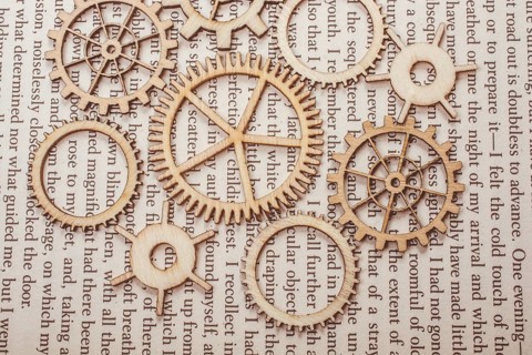Wooden cogwheels on a page of a book. Industry concept information