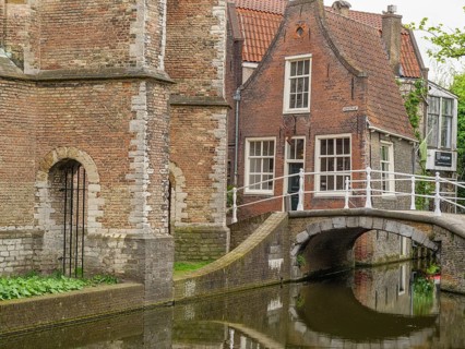 Historic brick building on a canal with small bridges and green surroundings, Delft, Netherlands