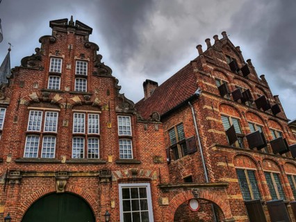 Historic brick houses with ornate facades, dramatic clouds in the sky, zutphen, gelderland,