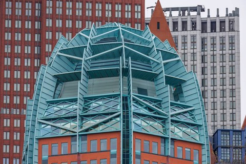 Detailed view of a modern building with a striking architectural design of glass and steel, den