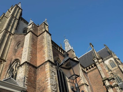 Large Gothic building with richly decorated towers and a black street lamp in front of it