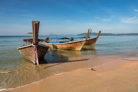 Tropical islands view with long tail boat ocean blue sea water and white sand beach, Krabi Thailand