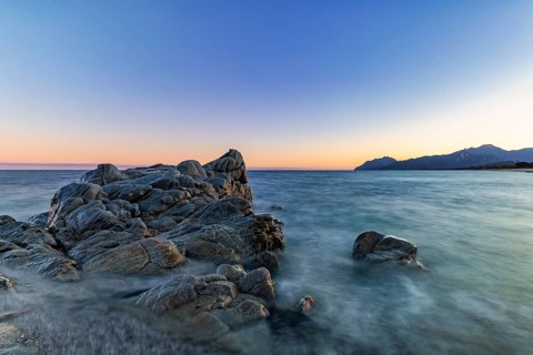 Rocks in the sea on the beach of Torre di Bari at sunset, long exposure, Torre di Bari, Bari Sardo,