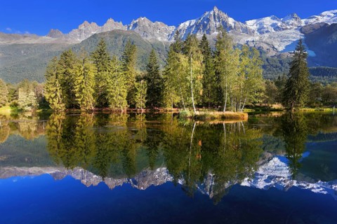 Dreamlike beauty lake and park. In smooth water reflected snow-capped mountains surrounding the