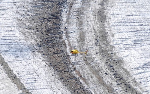 Helicopter flight over the Vadret Pers glacier underneath Piz Palü in the Bernina massif .