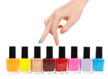 Female hand fingers are the colored paints polish on a white background