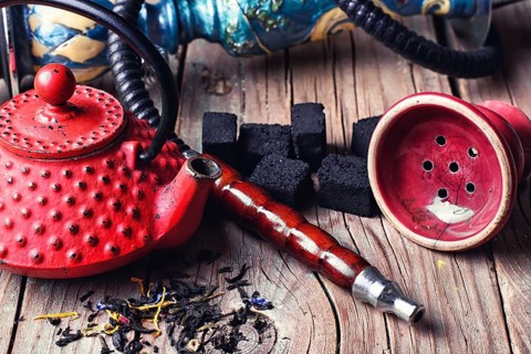 Details of Smoking hookah and red metal kettle spilled tea leaf