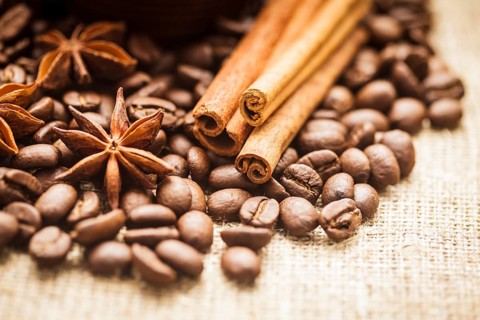 Spilled coffee beans with cinnamon and anise