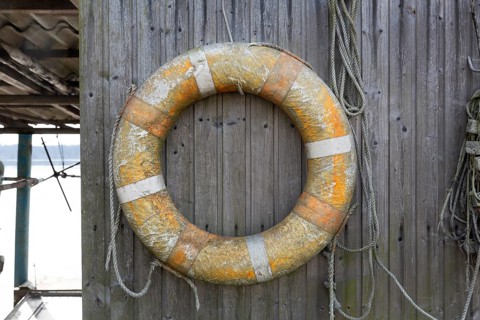 Old lifebuoy on a plank wall