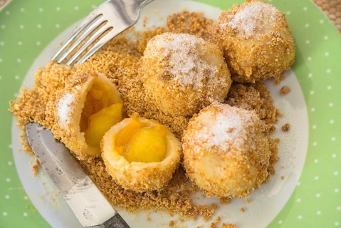 Real apricot dumplings with breadcrumbs and sugar on a plate - fruit dumplings