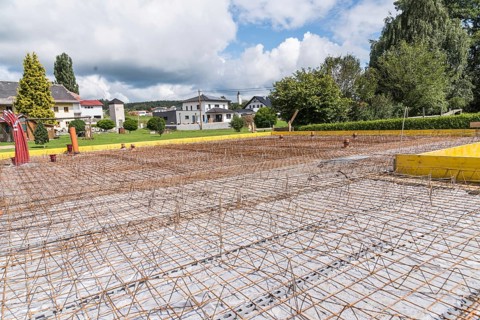 House construction site with steel grid for concrete foundation slab, construction industry