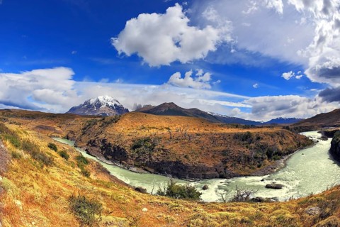 Travel to Chile. The river bends a horseshoe under the flying clouds. The picture was taken Fisheye