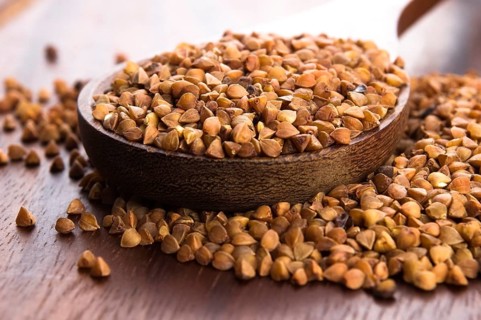 Buckwheat seeds on wooden spoon in closeup, lodz, poland