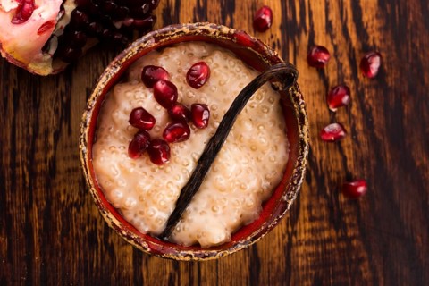 A bowl of tapioca pudding with vanilla and pomegranate