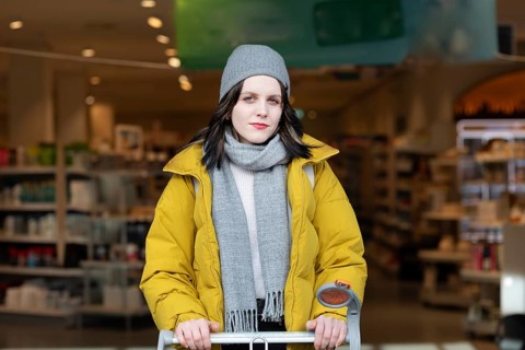 Woman in winter clothes shopping with a shopping trolley on foot, mobility, environmentally