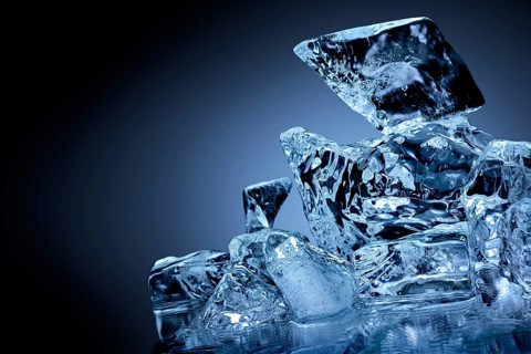 Frozen block of ice with blue tinted background