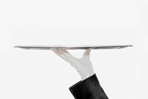 Waiter with white hemp shoes carries a silver tray