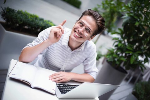 Happy handsome businessman mixes his break and job outdoors, businessman with headphones write some