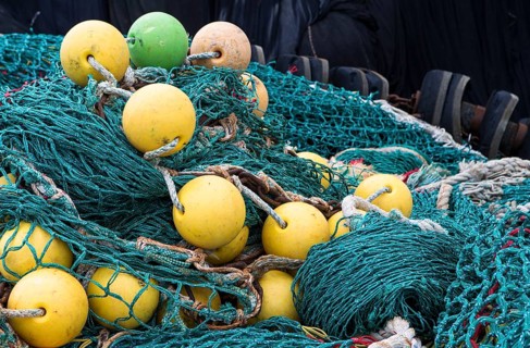 The photo shows a pile of fishing nets with floats