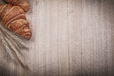 Ripe wheat rye ears fresh-baked croissants on wooden board