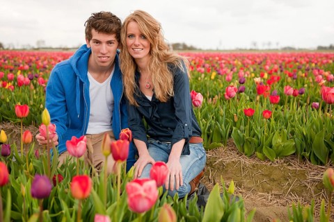 Couple Dutch tourists are plucking tulips in the flower fields