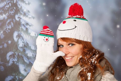 Portrait of woman in winter with snow and snowman hat