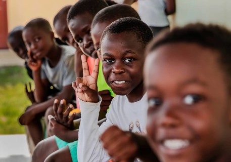 Children making a peace sign with their hands. Snapshot. It was taken during a rubbish collection