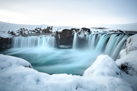A majestic waterfall surrounded by snow and ice in a wintry landscape, Iceland, Godafoss, Europe