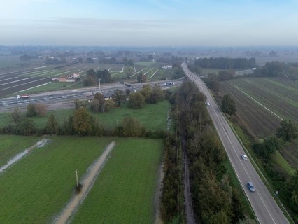Aerial view of a highway crossing the italian countryside after heavy rain, with flooded fields and