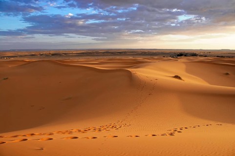 Endless sand dune landscape with footprints in the soft desert sand, sand dunes of Erg Chebbi,
