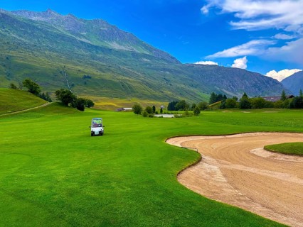 Beautiful Modern Luxury Golf Cart on Golf Course with Sand Trap and with Mountain View in the Swiss