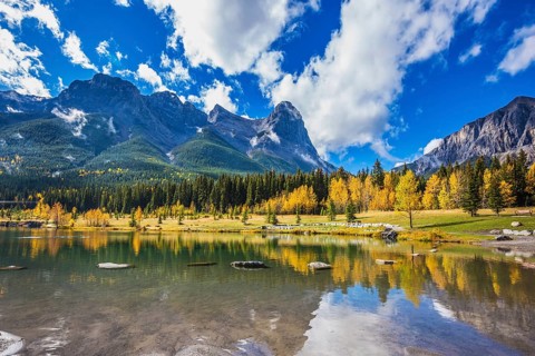 Shallow lakes surrounded by forests and mountains. Shining day in Canmore, Canadian Rockies.