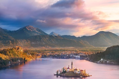 Colorful sunrise over the Bled lake, its surrounding hills, its island and the Karawanks mountains