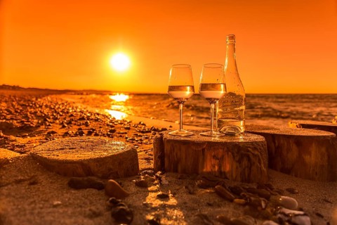 Wine on the baltic sea beach at sunset