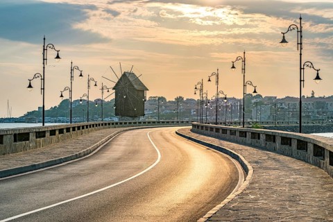 The wooden windmill on the isthmus at sunrise in Nessebar ancient city on the Bulgarian Black Sea