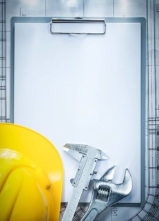 Clipboard building helmet adjustable spanner vernier caliper on blueprint construction concept