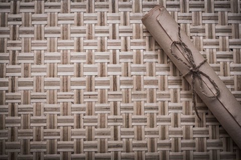 Vintage rolled corded paper on woven wooden matting