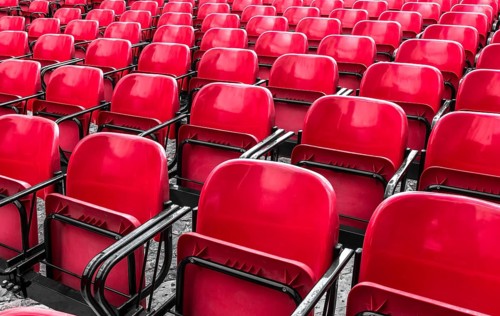 Empty plastic red chairs In outdoor theater in sunny day