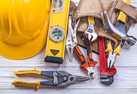 Composition of building implements leather tool belt building helmet on wooden board