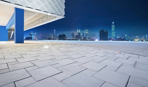 Perspective view of empty floor with modern building exterior and cityscape skyline . Night scene