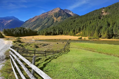 Rural idyll. Headwaters National Park Krimml waterfalls. Farm fields separated from the dirt road