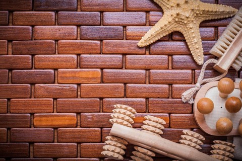 Starfish wood massagers and bath brush on textured wooden table mat sauna concept